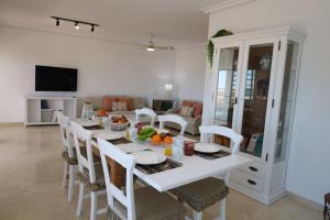 a white dining room with a white table and chairs at Increíble casa frente a la playa de Muchavista Alicante By ElConserje in El Campello