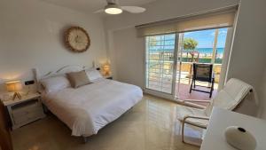 a bedroom with a bed and a view of the ocean at Increíble casa frente a la playa de Muchavista Alicante By ElConserje in El Campello +54 photos