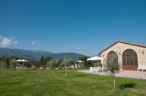 um jardim com mesas e cadeiras e um edifício em AGRITURISMO La COLLINA del SOLE em Coltavolino