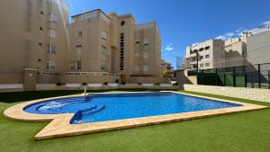 a swimming pool in front of some buildings at Increíble casa frente a la playa de Muchavista Alicante By ElConserje in El Campello