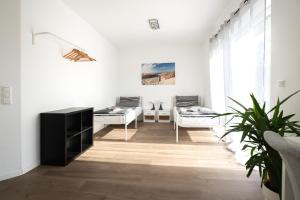 a white living room with white furniture and a plant at Ferienhof am Glück in Bad Zwischenahn