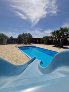 Una piscina azul con un tobogán en un complejo turístico. en Sunny Stay - Mobile home 1 minute from beach with free parking and wifi!, en Pirovac