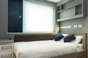 a bedroom with a large bed with a window at For Students Only Collegiate Eclipse Cardiff in Cardiff