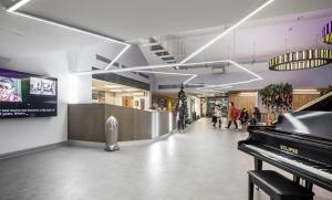 a lobby with a piano and people in a building at For Students Only Collegiate Eclipse Cardiff in Cardiff
