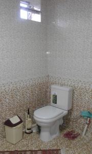 a bathroom with a toilet in a tiled room at Kyrgyz Family in Bokonbayevo
