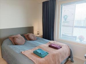 a bedroom with a bed with two pillows on it at Lovely new city apartment all amenities in Seinäjoki