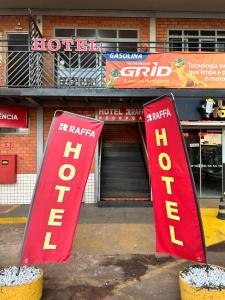 due cartelli rossi davanti a un hotel di Hotel Raffa a Bandeirantes