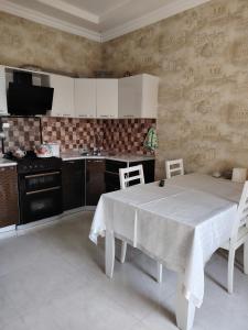 cocina con mesa y mantel blanco en Garden House, en Mekhrably 23 fotos más