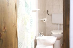 a bathroom with a toilet and a shower curtain at Corte De Tomasi- Centro storico in Gallipoli +27 photos
