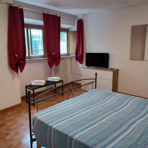 a bedroom with a bed and red curtains and a tv at Inti in Lucca