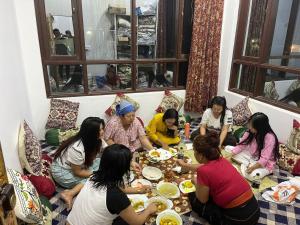 Un gruppo di donne sedute a tavola a mangiare cibo di The Light House a Srinagar