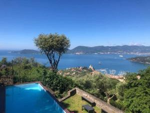una piscina con vista su un bacino d'acqua di Lovely House with private pool 3X2 with jacuzzi and breakfast with garden and BBQ next seaside and train station a Sarzana