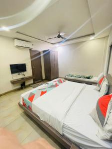 a bedroom with a large bed and a flat screen tv at Hotels SVL in Indore