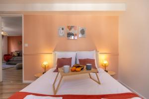 a bedroom with a bed with a tray of fruit on it at Le Corallo - T2 cosy et moderne en hyper-centre in Bergerac