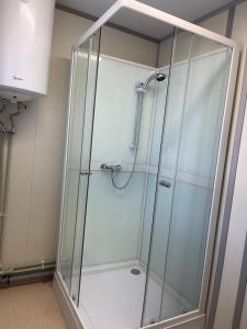 a shower with a glass enclosure in a bathroom at ModulHaus Pabradeje Trumpalaike Nakvyne in Pabradė