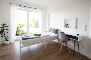 a bedroom with a bed and a desk and a window at Ferienhof am Glück in Bad Zwischenahn