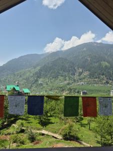 a view of the mountains from a hillside with prayer flags at The Green Mountain Lodge in Jāmb