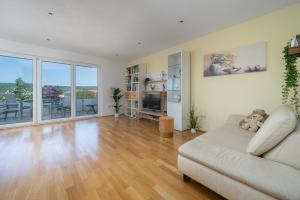 a living room with a couch and a television at Seeliebe und Gartenglück in Bodman-Ludwigshafen