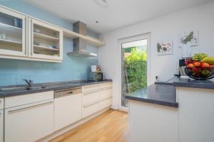 a kitchen with white cabinets and a bowl of fruit on the counter at Seeliebe und Gartenglück in Bodman-Ludwigshafen +14 photos