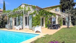 a villa with a swimming pool in front of a house at Villa Notre-Dame avec piscine in Rochefort-du-Gard +63 photos