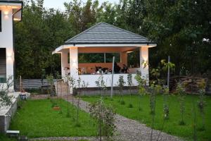 a gazebo in a garden with people sitting in it at Casa Movilita El DoD in Moviliţa