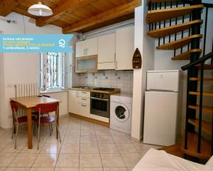 eine Küche mit einem Tisch, einem Herd und einem Kühlschrank in der Unterkunft Numana, delizioso cielo-terra a 150mt dal mare - N099 in Numana