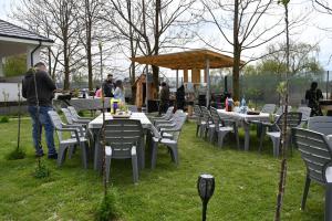 a man standing in a yard with tables and chairs at Casa Movilita El DoD in Moviliţa