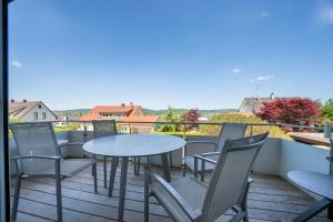a patio with tables and chairs on a balcony at Seeliebe und Gartenglück in Bodman-Ludwigshafen