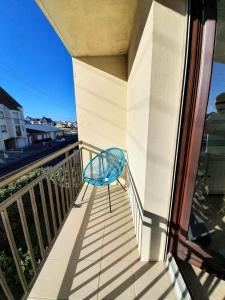 a blue chair sitting on the balcony of a building at Studio a Berck proche plage in Berck-sur-Mer +5 photos