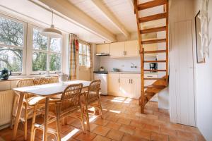 a kitchen and dining room with a table and chairs at De Koevoet in Teroele