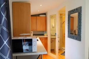 una cucina con armadi in legno e forno a microonde bianco di J home a Villeneuve-le-Roi Altre 10 foto