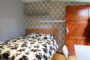 una camera da letto con un letto con un piumone bianco e nero di J home a Villeneuve-le-Roi