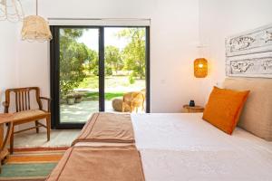 una camera da letto con un letto e una porta scorrevole in vetro di Lugar das Sesmarias a Pinhal Novo