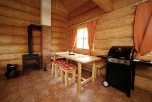 uma cozinha com uma mesa e um fogão numa cabina de madeira em Na Samotě Ve Srubu em Plzeň