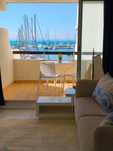 ein Wohnzimmer mit Sofa, Tisch und Stühlen in der Unterkunft Adoya plage Studio cabine vue port et mer in Le Grau-du-Roi