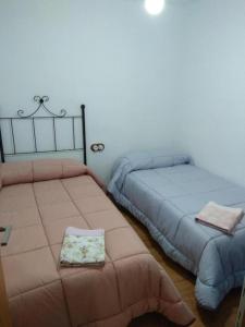 Dos camas una al lado de la otra en un dormitorio. en Casa Rural El Albergue, en Beires