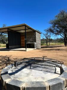 a building with a bench in front of it at Northern Rock Campsites in Otjiwarongo