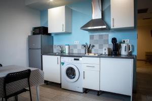 a kitchen with a washing machine and a washer at Apartamentos Comfort Calella in Calella