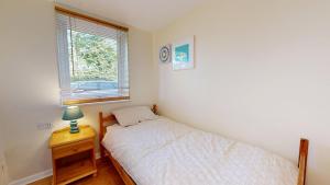 une petite chambre avec un lit et une fenêtre dans l'établissement Bryntin, à Penzance 17 autres photos