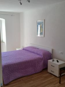 a bedroom with a purple bed and a table at Holiday Home Casa Matilde in Koromačno