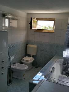 a bathroom with a toilet and a sink and a tub at Holiday Home Casa Matilde in Koromačno