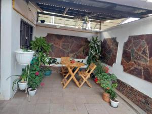 コチャバンバにあるEl Descansoの屋外パティオ(木製テーブル、鉢植えの植物付)