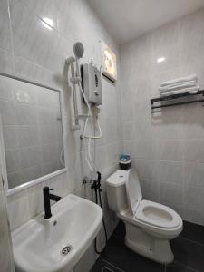 a bathroom with a white toilet and a sink at Reds Roomstay Pantai Penarik 1 in Pulau Che Selamah