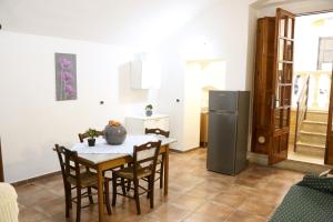 a kitchen with a table with chairs and a refrigerator at Corte Micetti 2- Centro storico in Gallipoli