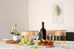 a table with a bottle of wine and plates of food at Corte Micetti 1- Centro storico in Gallipoli +33 photos