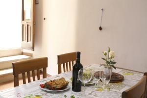 a table with a bottle of wine and a plate of food at Corte Micetti 1- Centro storico in Gallipoli