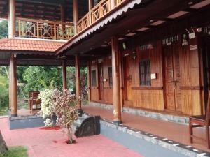 - une vue sur l'extérieur d'un bâtiment avec une terrasse couverte dans l'établissement AquaPalace-The heritage homestage, à Champakulam
