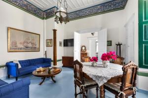 a living room with a table and a blue couch at 1800 MANSION in Spetses