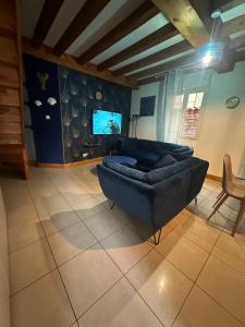 a living room with a couch and a tv at Le 8 appartement - Le Duplex III - parking sur demande in Mâcon