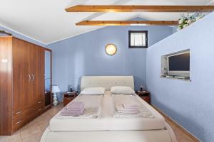 une chambre avec un lit et une télévision sur un mur dans l'établissement Casa Jelena with Shared Pool, à Kaštelir